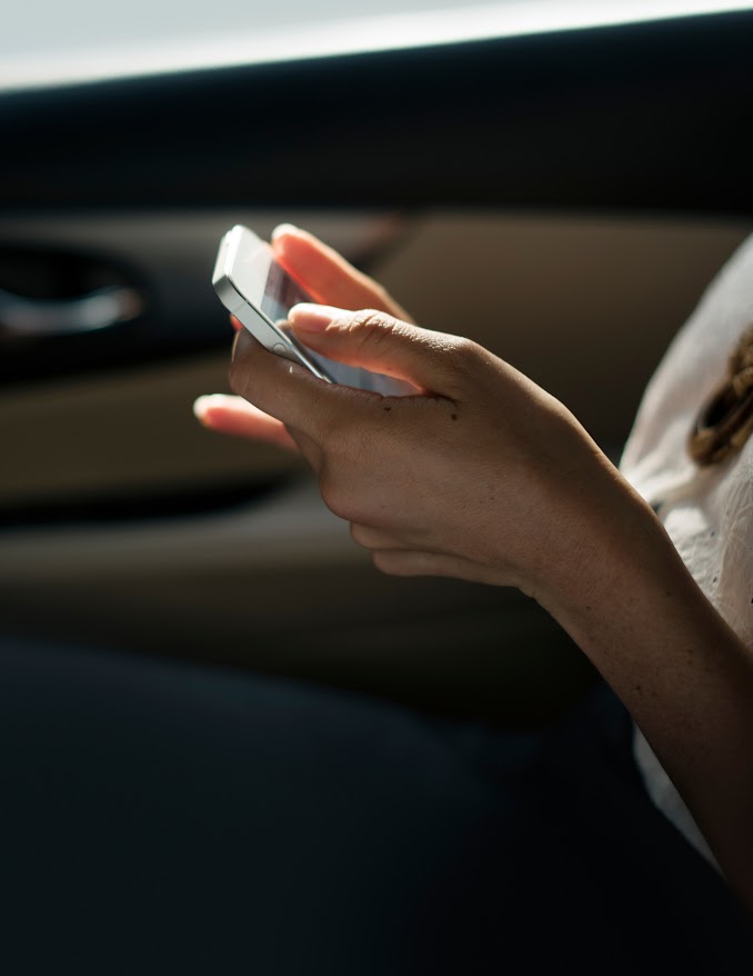 Businesswoman checking her phone during a car ride